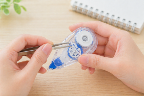 ピンセットで修正テープを整えている